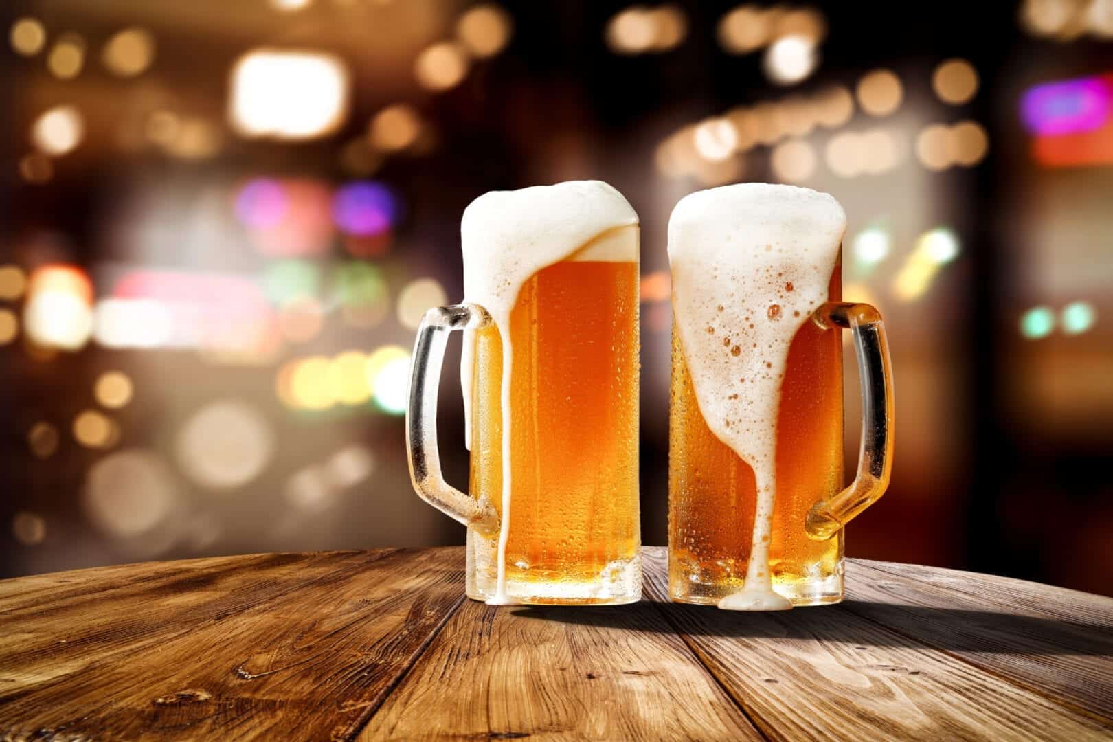 Fresh cold beer in glass and free space for your bottle. Bar interior background